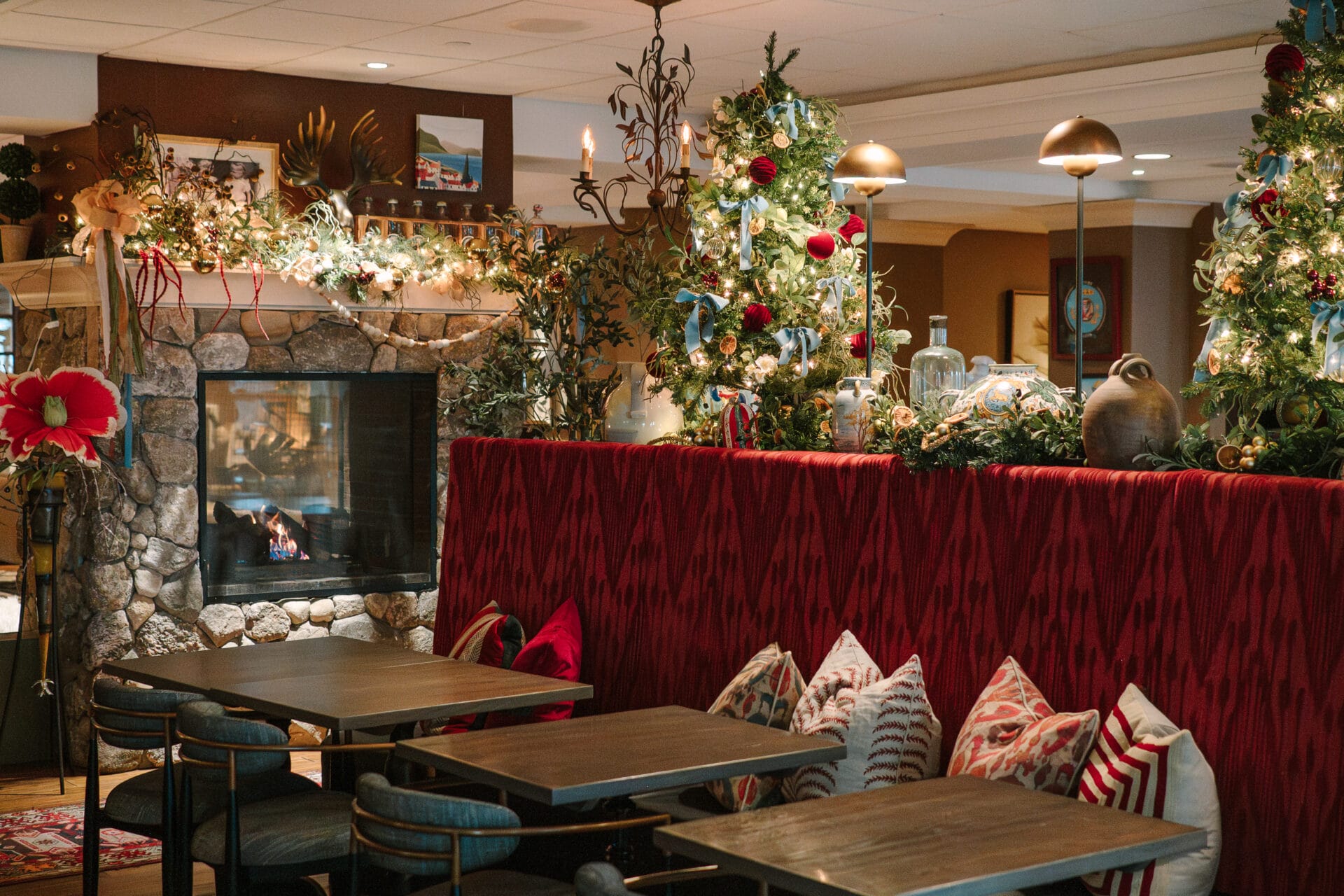 tables and chairs in a restaurant with a fireplace and christmas decorations